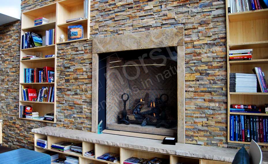 Close-up of a Stone Fireplace Wall with built in wood bookshelves in an architect lobby in Denver