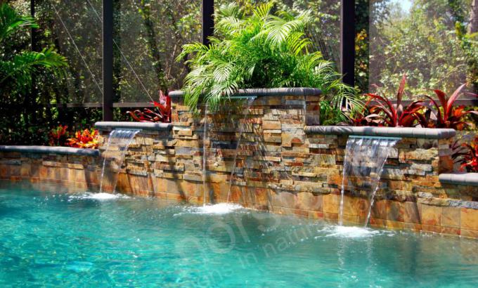 Thin Stone Veneer used under cascading water fall on rising back wall of a pool in Orlando Florida