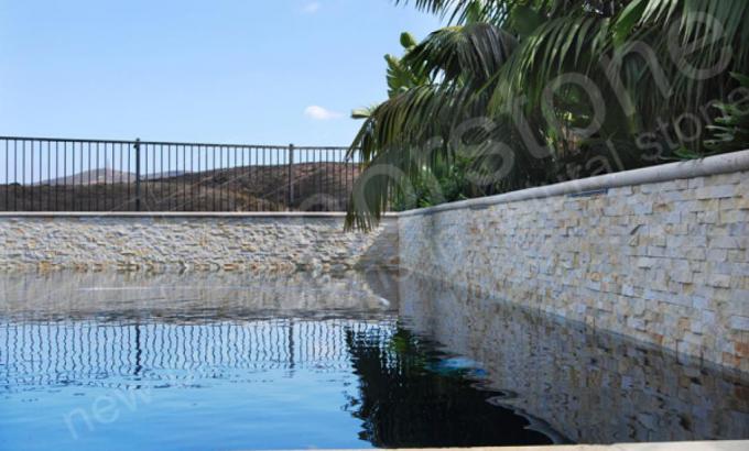Ivory Quartz Stacked Stone Waterline Tile used around waters edge of a pool in San Diego