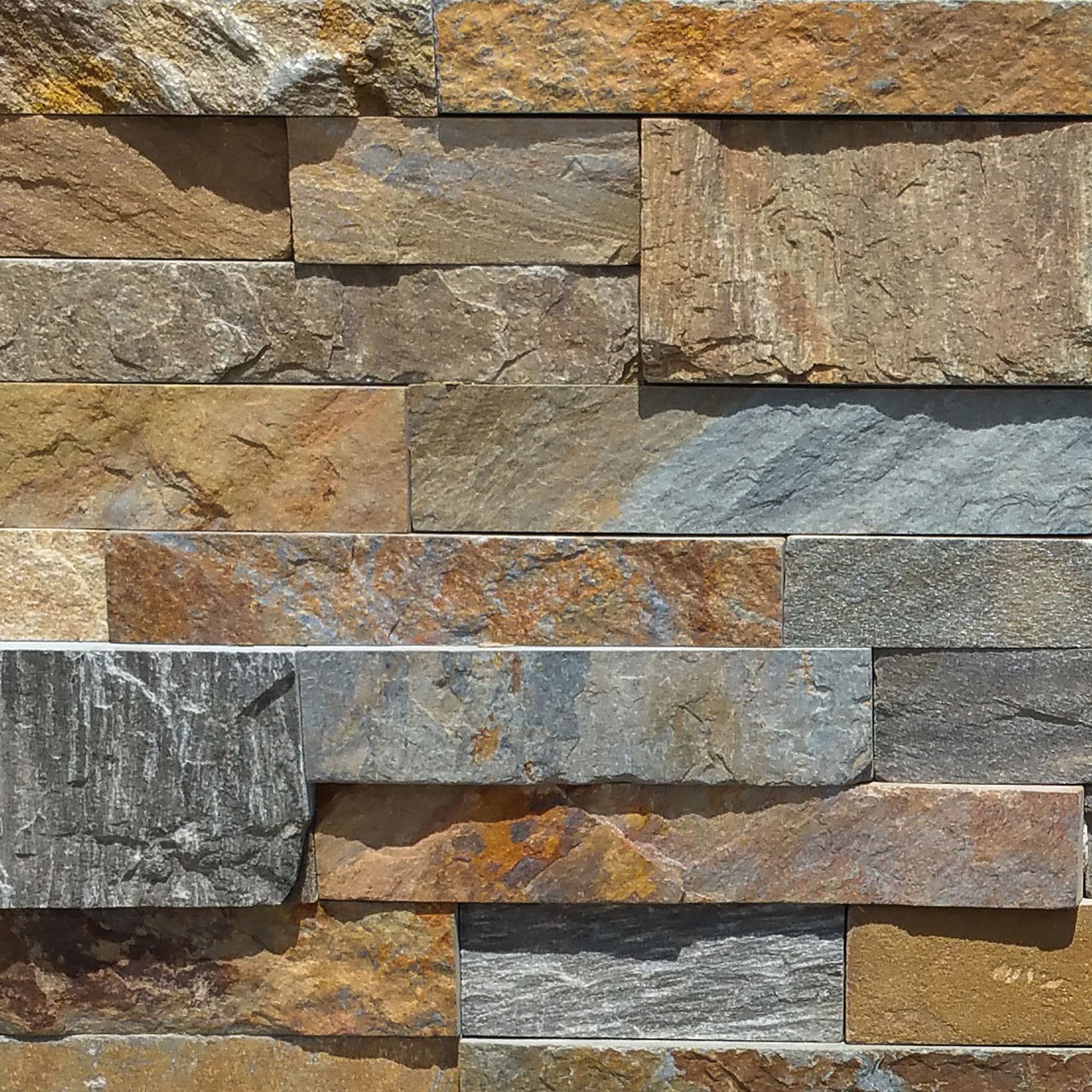 A close-up view of a stone wall with rectangular, unevenly sized blocks in shades of brown, tan, and gray, creating a natural, textured pattern—ideal for a high end stone design or elegant stone fireplace.