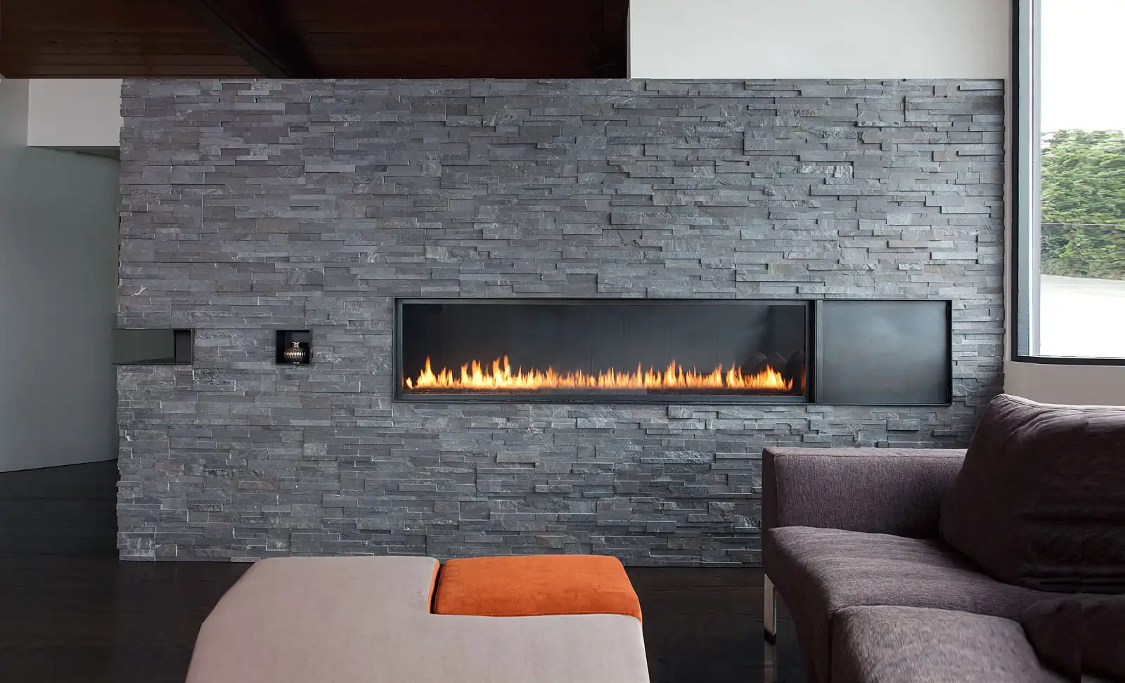 Norstone Charcoal Standard Rock Panels on a prominent residential fireplace with a long linear fireplace and cantilever cut in detail on the outside corner.