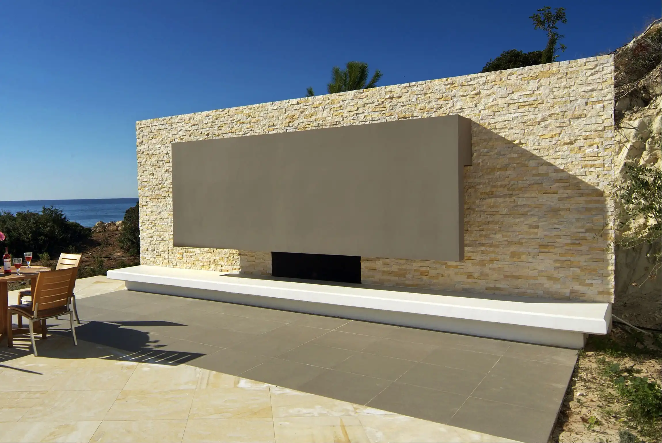 Norstone Ivory Standard Rock Panels on a uniqure exterior feature wall hiding residential utility equipment on an outdoor patio.