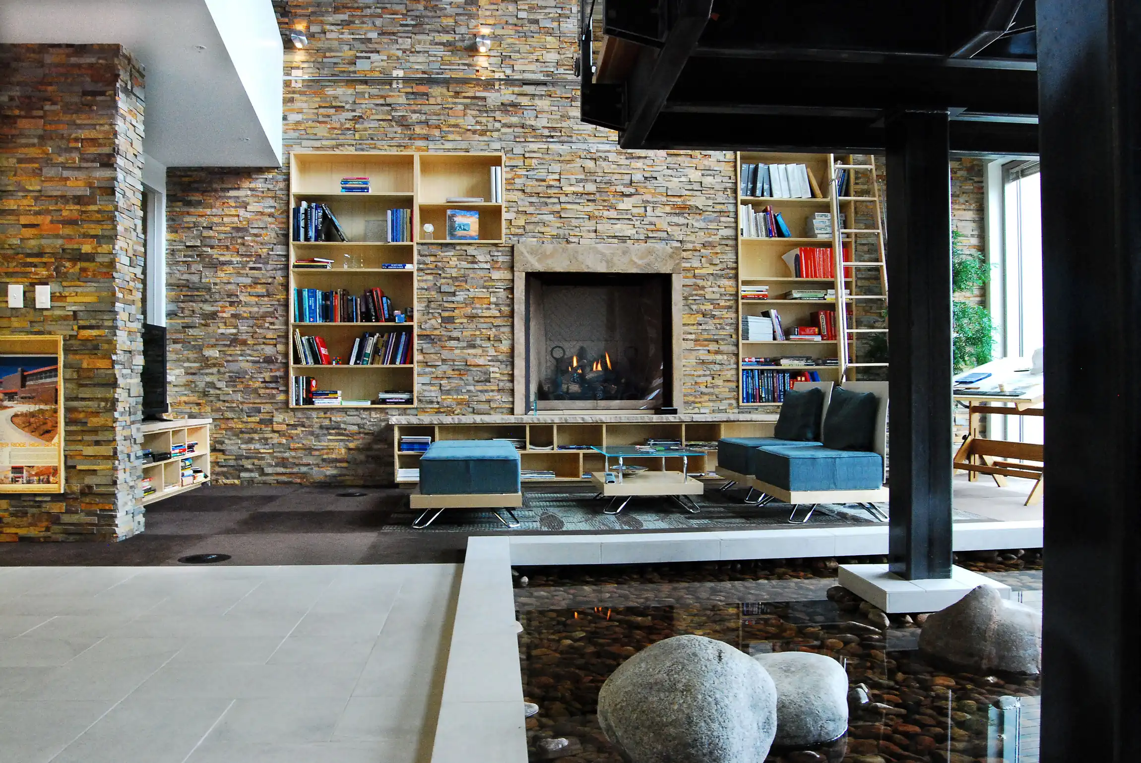 Norstone Ochre Blend Standard Rock Panels on a large airy feature wall with built in cabinets and a wood burning fireplace in an open air lobby space of an office building.