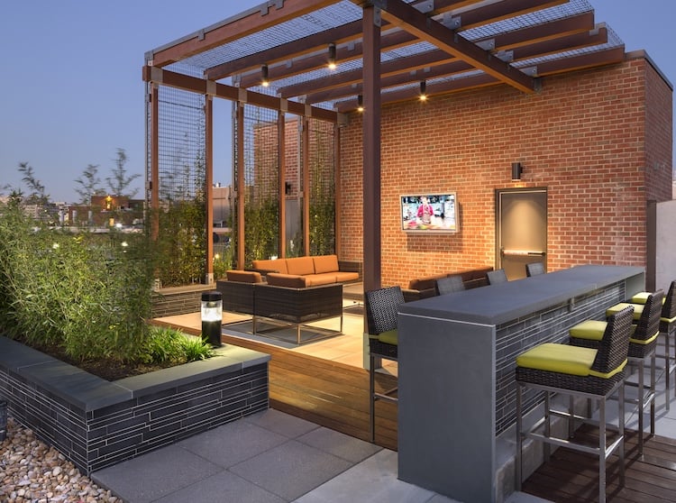 Norstone Grey Basaslt Lynia Tile on planter features on a rooftop patio of an urban apartment building.